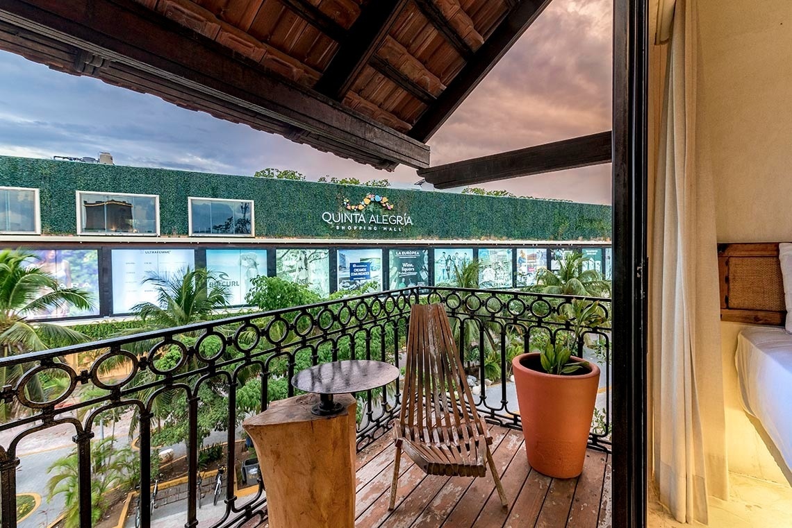 un balcón con una silla y una mesa frente a un quinta alegria