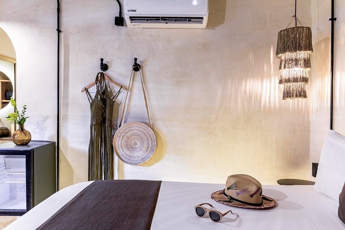 una cama con un sombrero y gafas de sol sobre ella