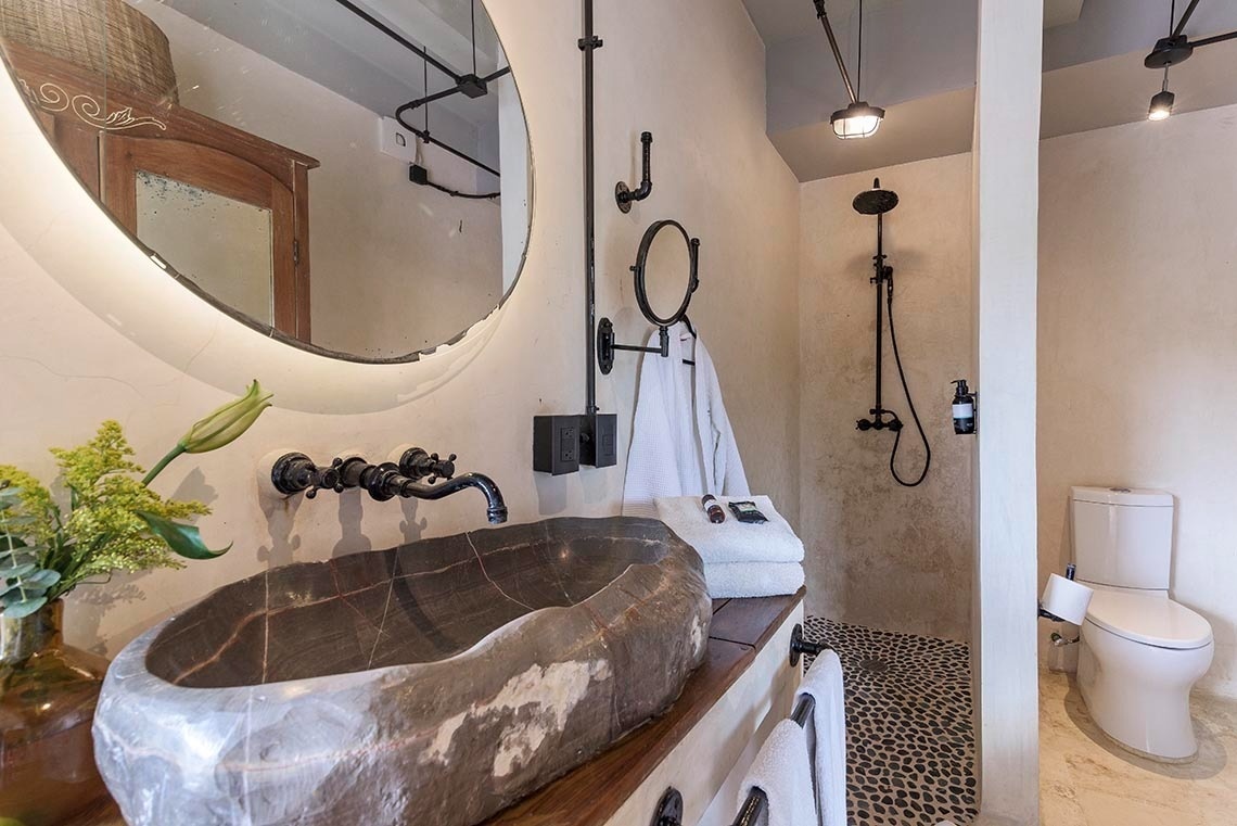 un baño con un lavabo de piedra y un inodoro