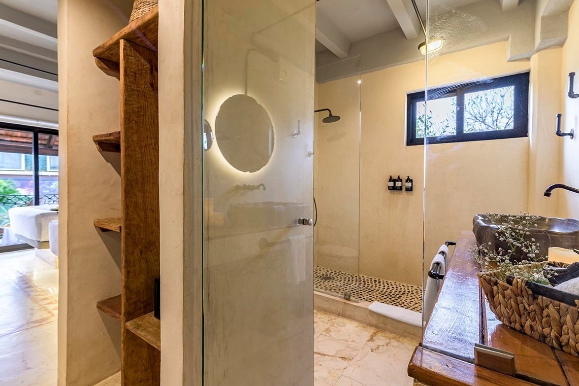 un baño con puerta de vidrio y lavabo de madera