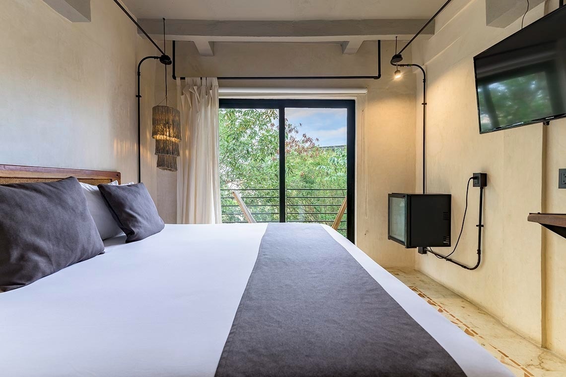 una habitación con una cama y una televisión en la pared