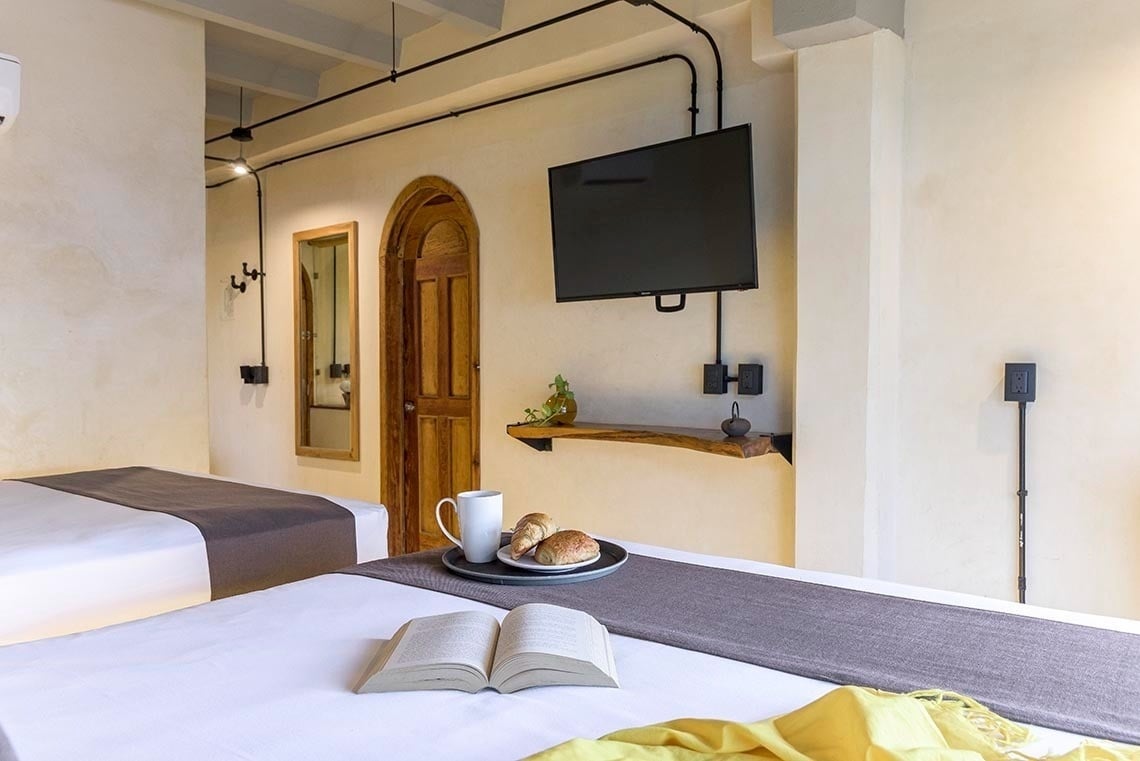 una cama con dos camas y una televisión en la pared