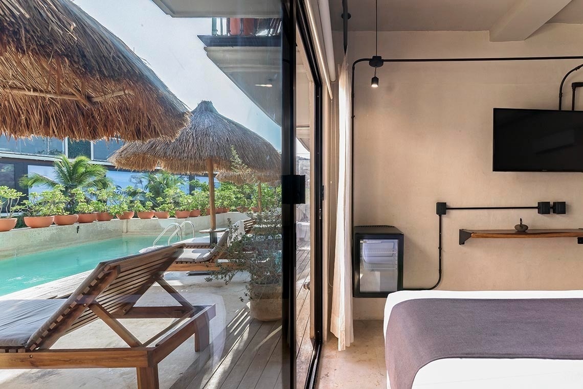 una habitación con una cama y una televisión con vista a una piscina