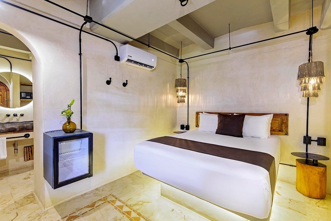 una habitación con una cama y una nevera pequeña