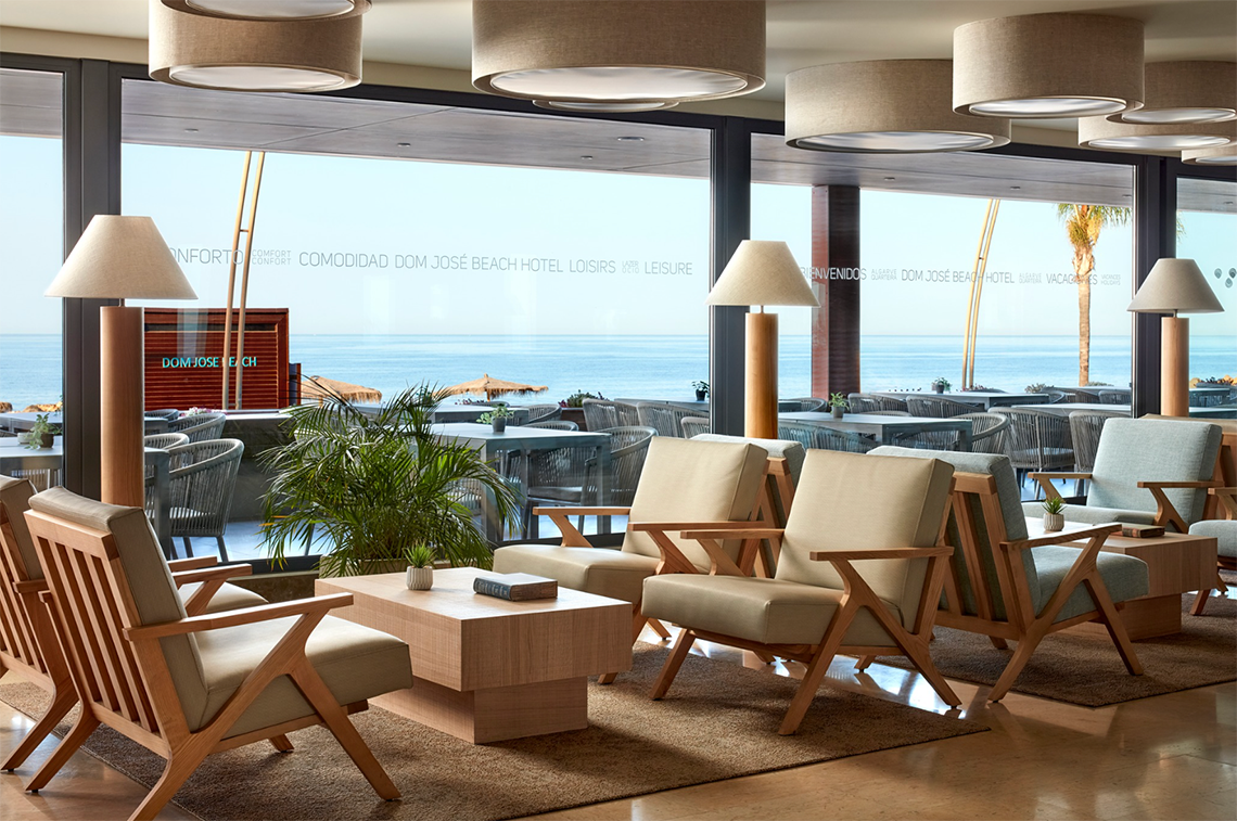 uma sala de estar com cadeiras e mesas em um hotel