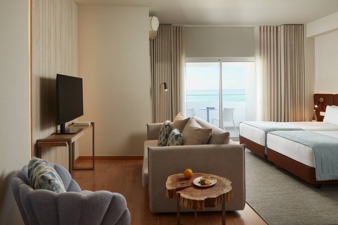 um quarto de hotel com duas camas e uma televisão