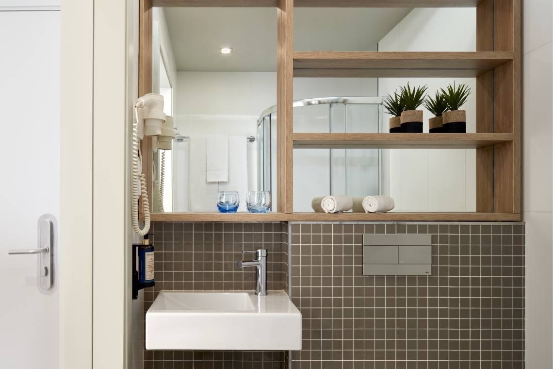 a bathroom with a sink a mirror and a hair dryer