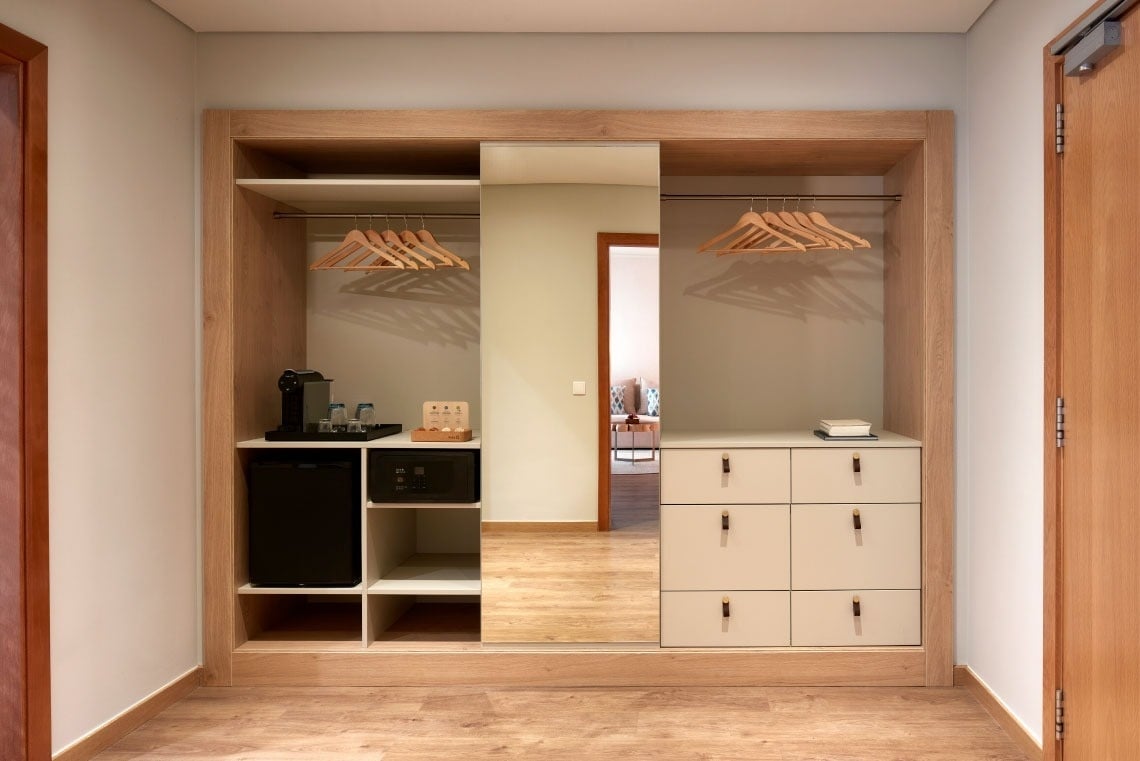 a closet with a small fridge and a coffee maker