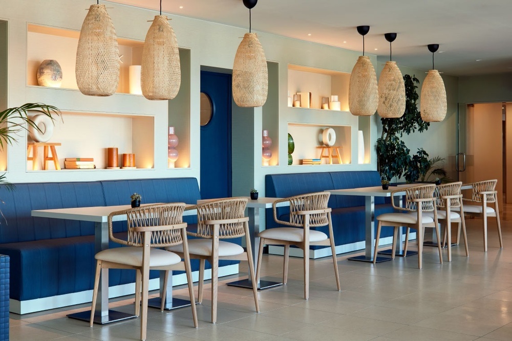 a restaurant with tables and chairs and a blue bench