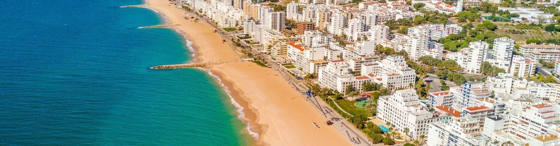 an aerial view of a beach with a city in the background