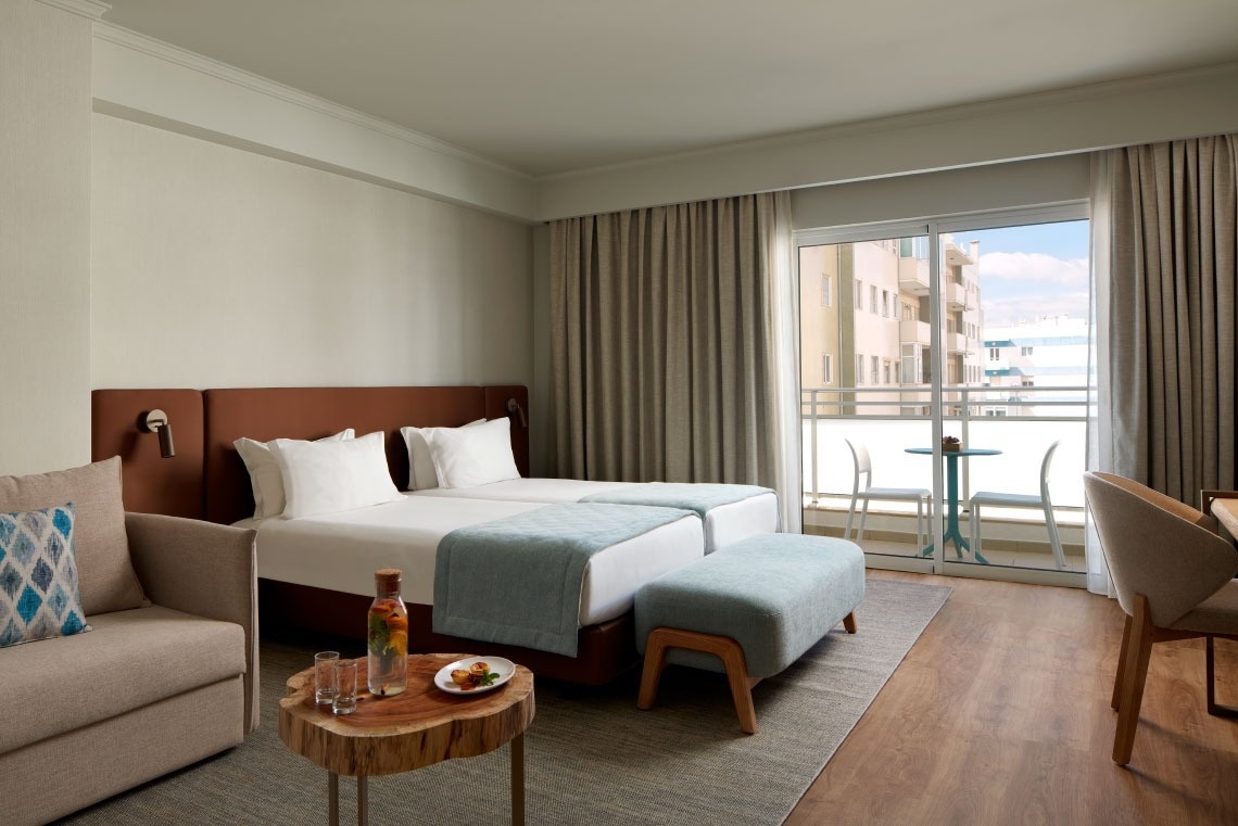 um quarto de hotel com duas camas e uma mesa de madeira