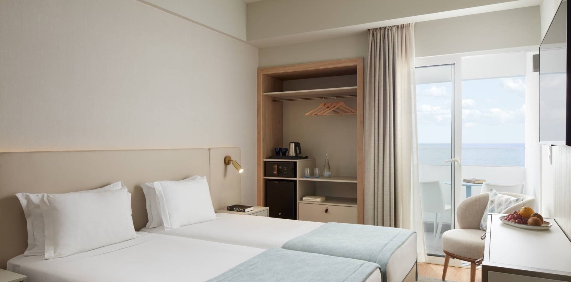 um quarto de hotel com duas camas e uma mesa