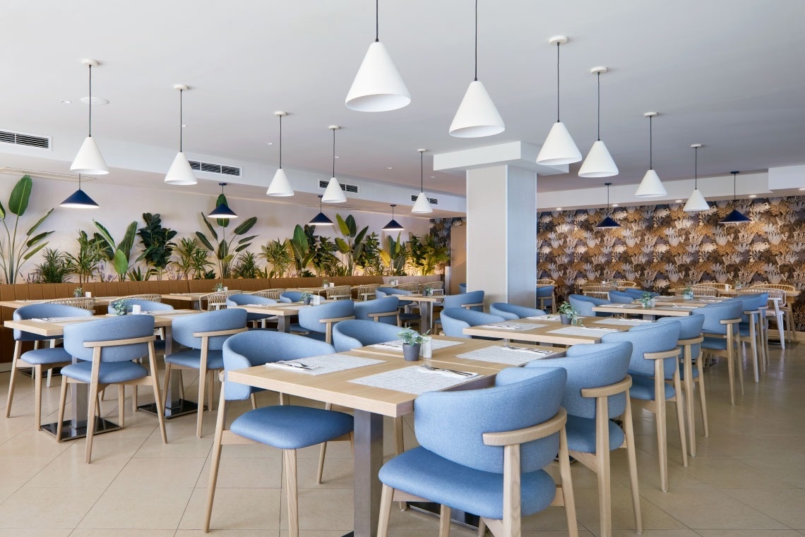 a dining room with blue chairs and white tables