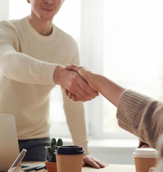 un homme et une femme se serrent la main à une table