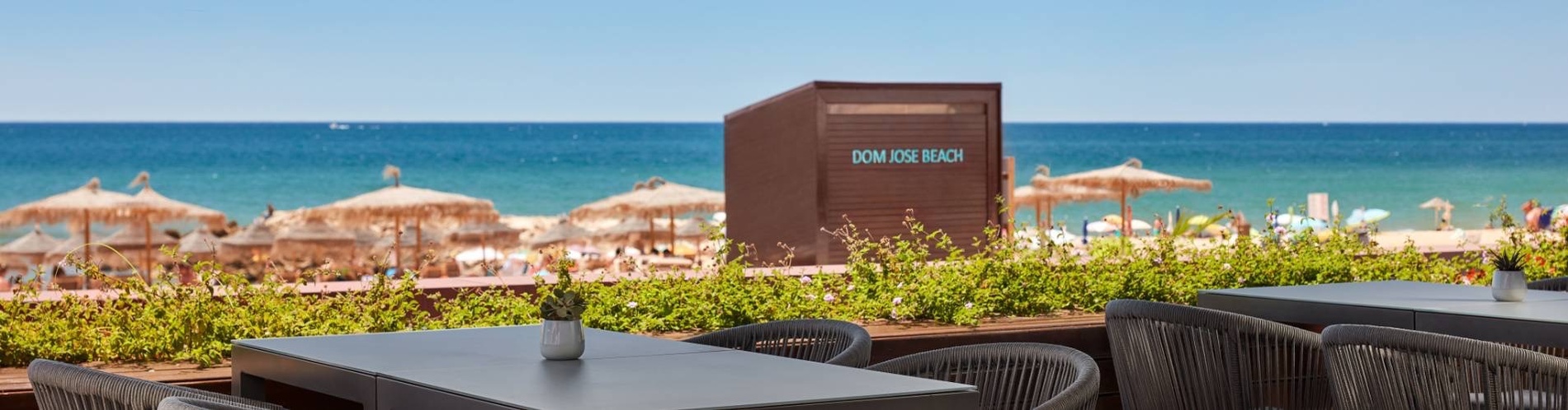 tables and chairs in front of a kiosk that says dom jose beach
