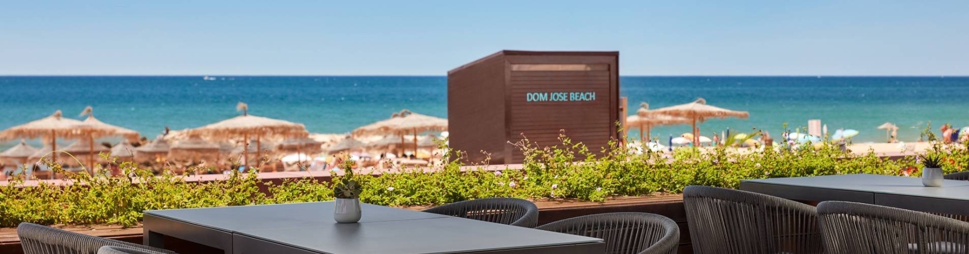 une plage avec des parasols et des tables et chaises