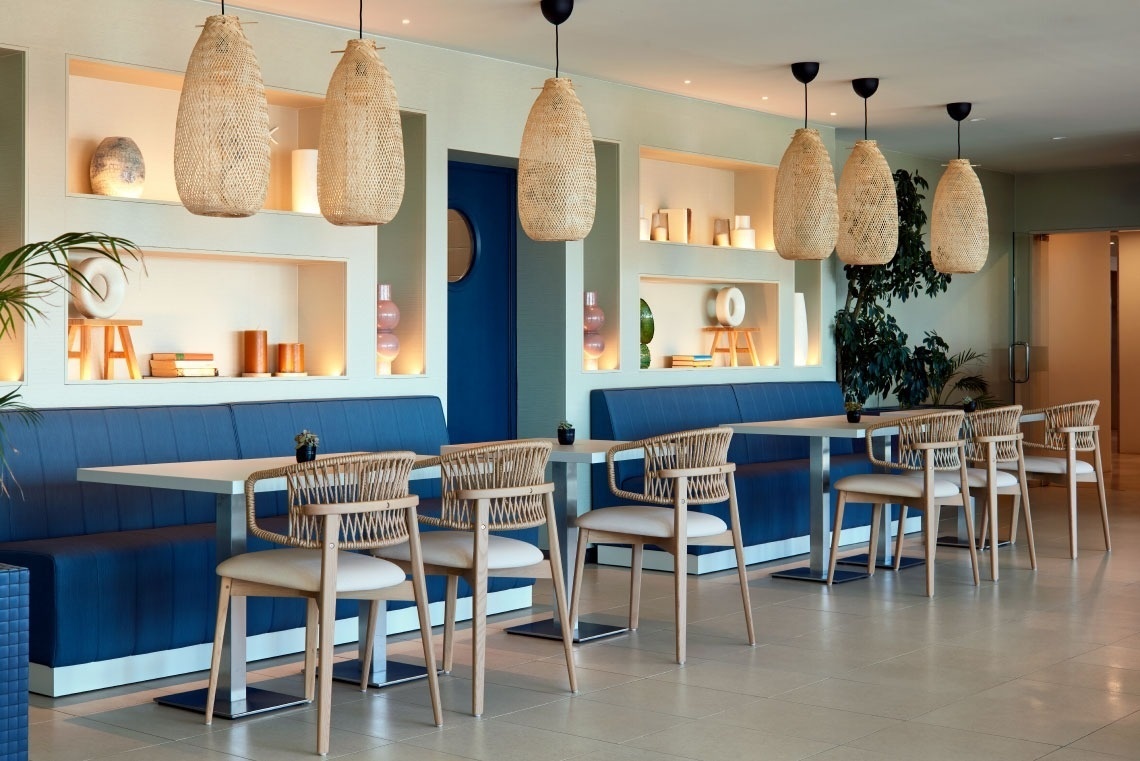 a restaurant with tables and chairs and a blue bench