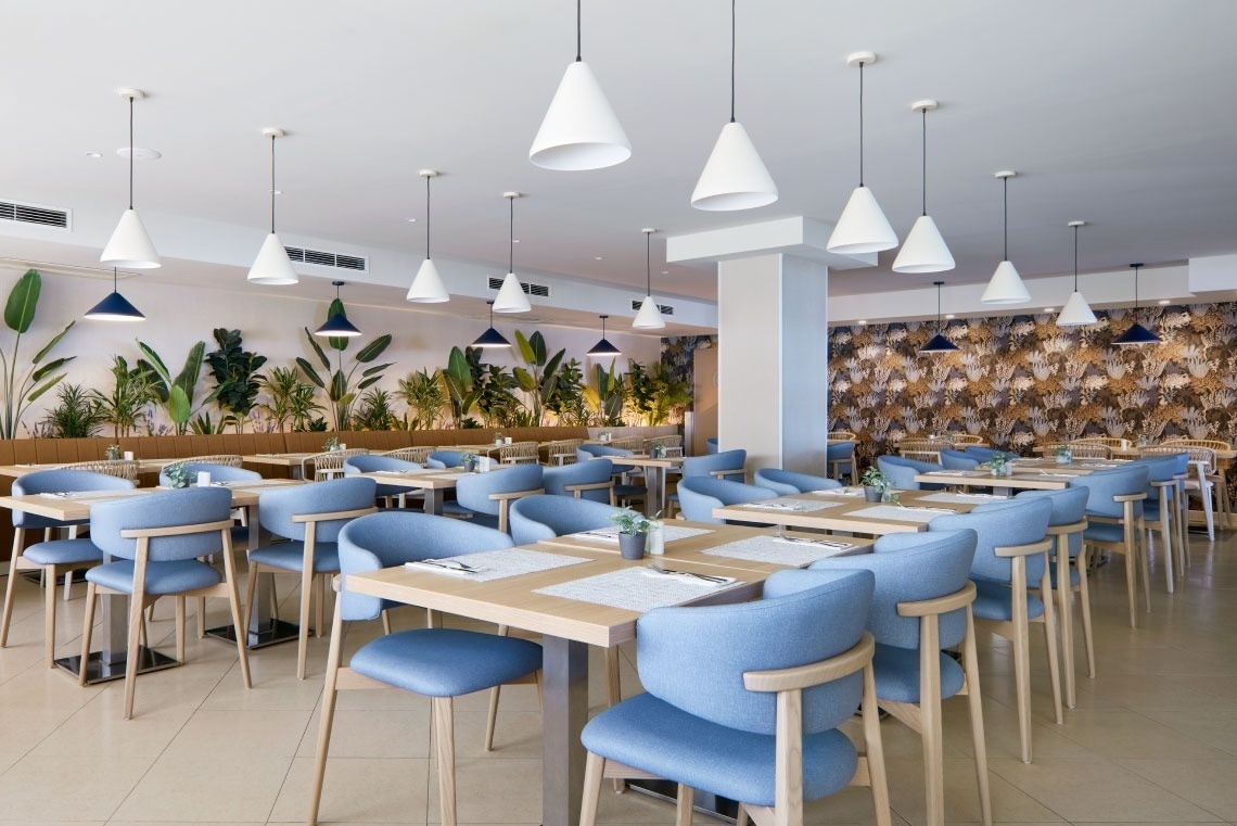 a restaurant with blue chairs and white tables