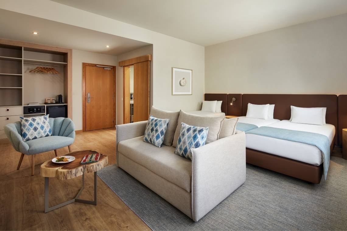 um quarto de hotel com duas camas e um sofá