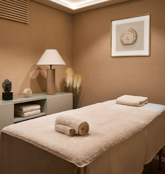 a picture of a sea shell hangs above a massage table