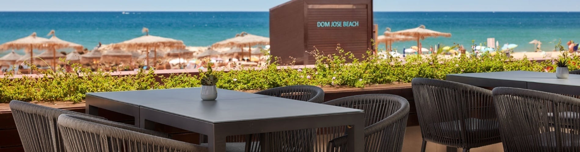 una mesa y sillas frente a una cabaña que dice dom jose beach