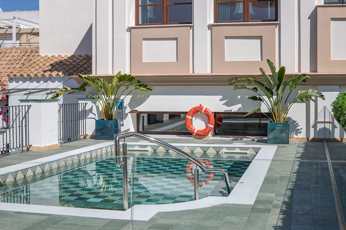 una piscina con escaleras que conducen a ella frente a un edificio
