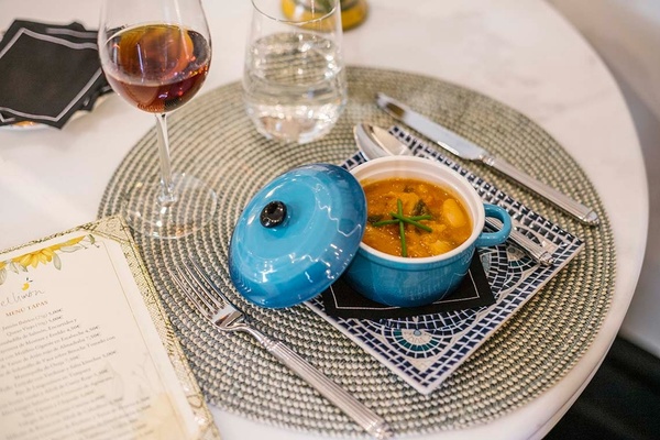 un plato de sopa y un vaso de vino en una mesa