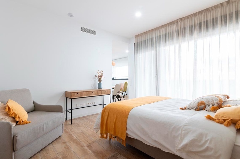 una cama con sábanas blancas y almohadas blancas