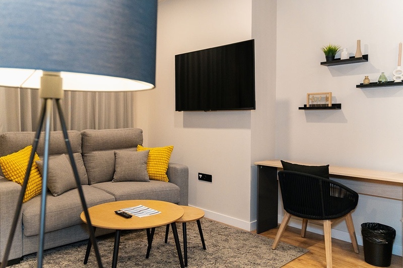 una habitación con una cama y un árbol en la pared