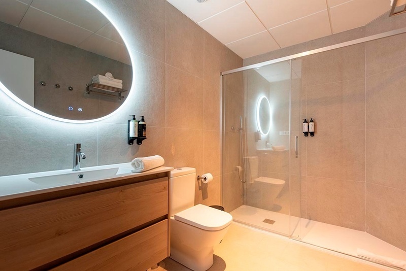 una cama con sábanas blancas y almohadas blancas