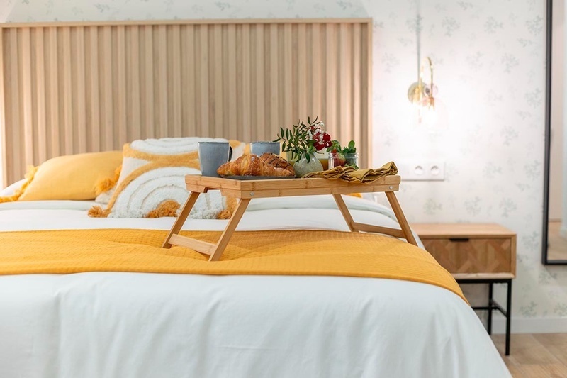 una cama con sábanas blancas y almohadas blancas