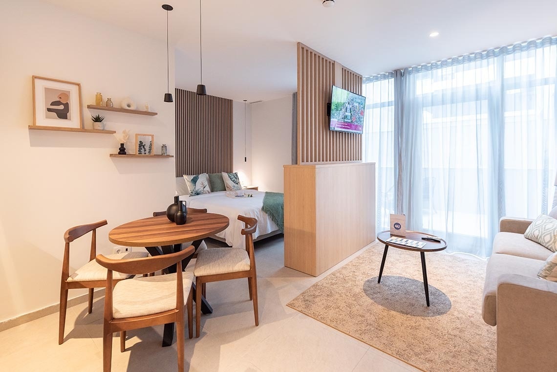 una habitación pequeña con una mesa y sillas y una televisión