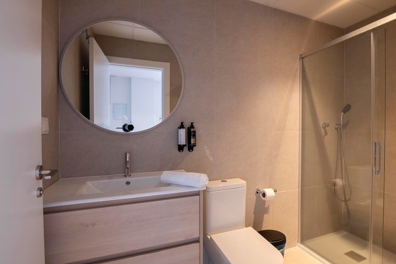 una cama con sábanas blancas y almohadas blancas