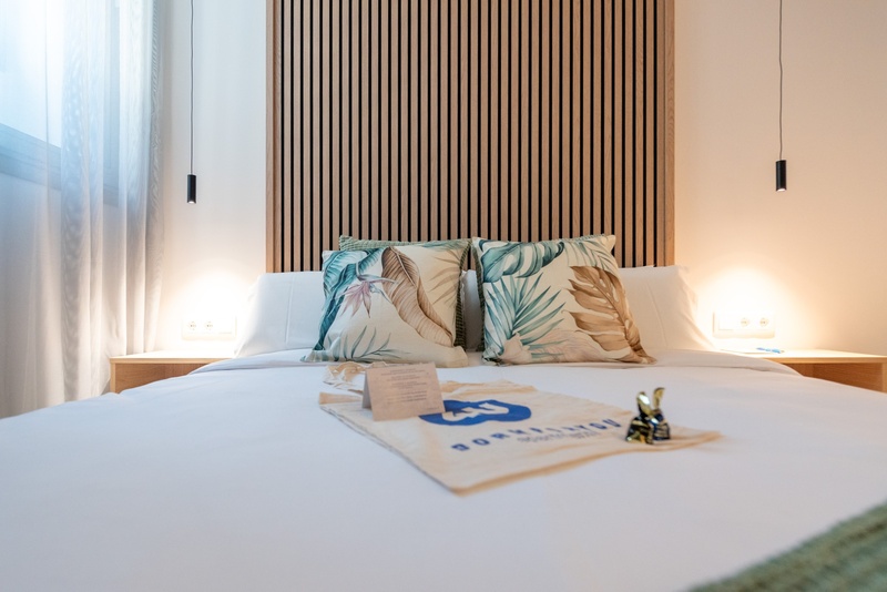 una cama con dos almohadas blancas y una cabecera de madera