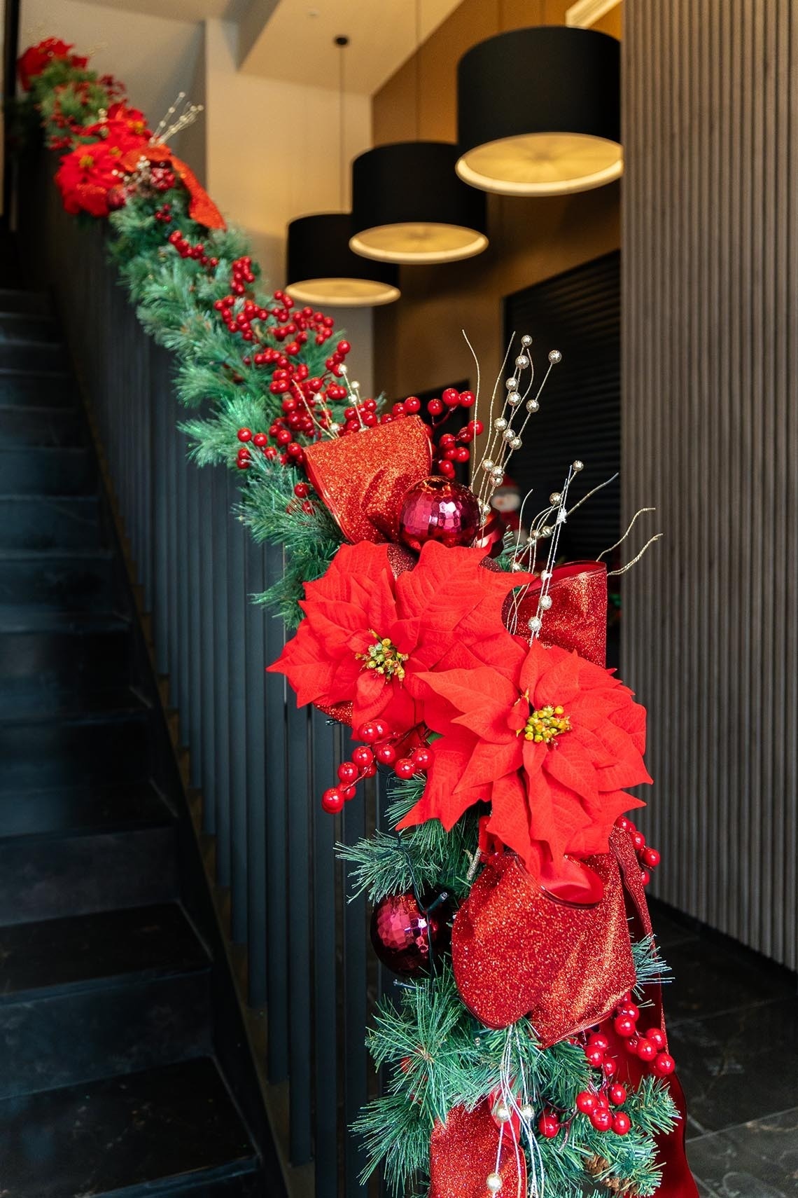 una escalera decorada para la navidad con flores rojas y bayas