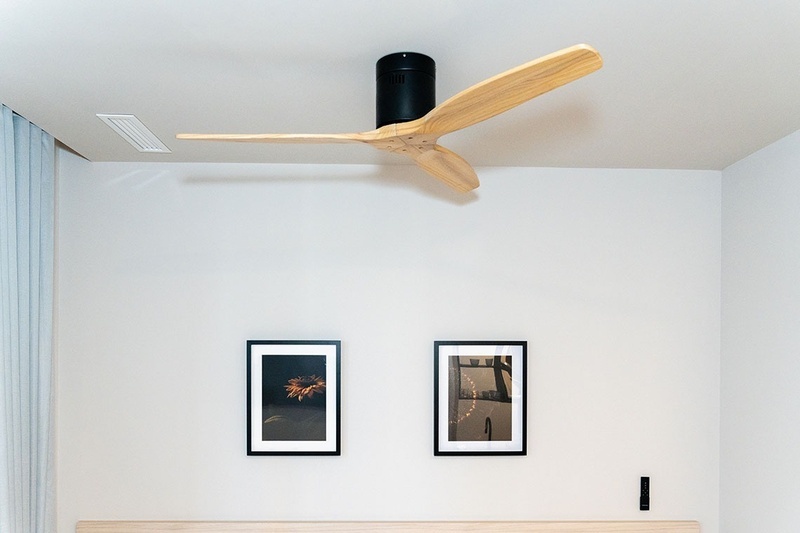 una cama con dos almohadas blancas y una cabecera de madera