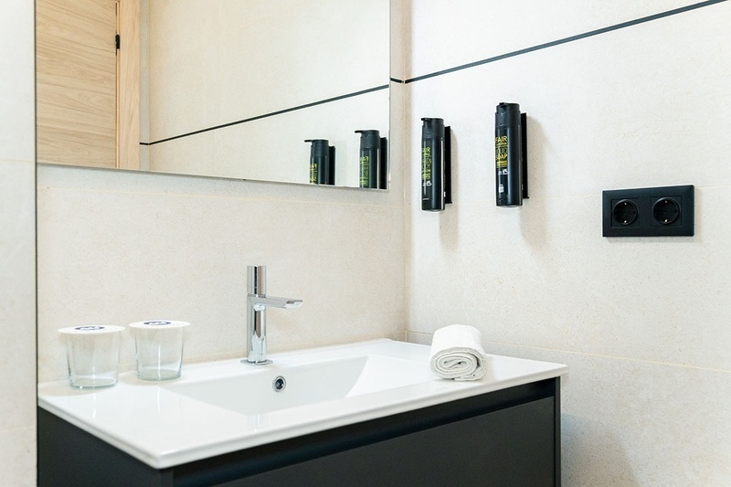 una habitación con una cama y un árbol en la pared