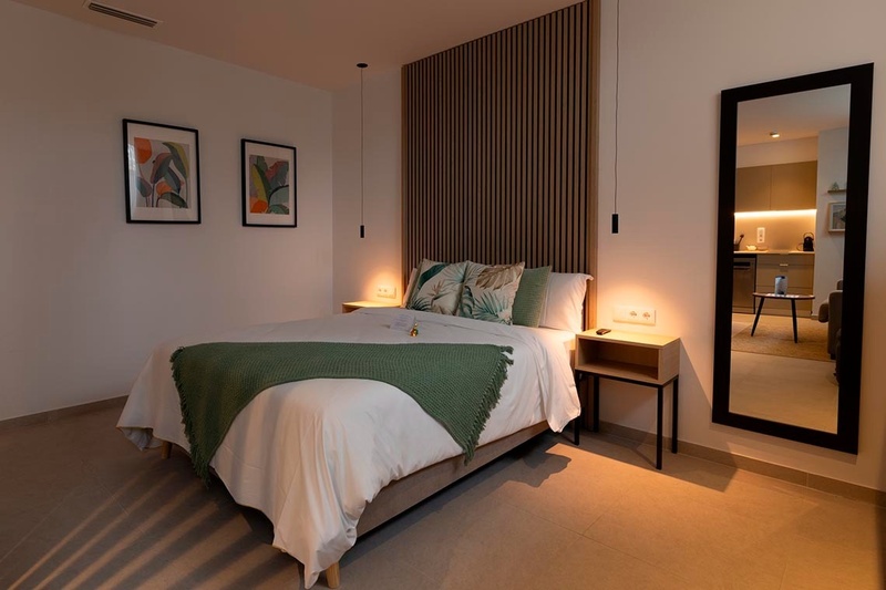 una cama con sábanas blancas y almohadas blancas