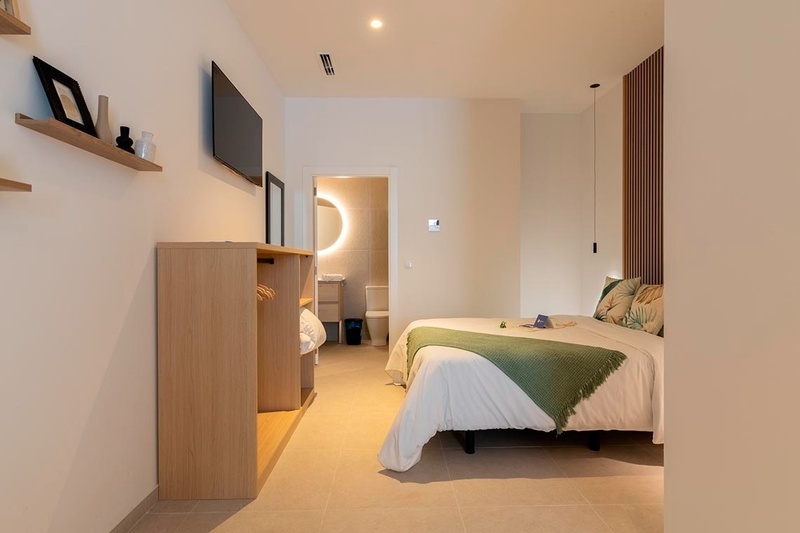 una cama con sábanas blancas y almohadas blancas