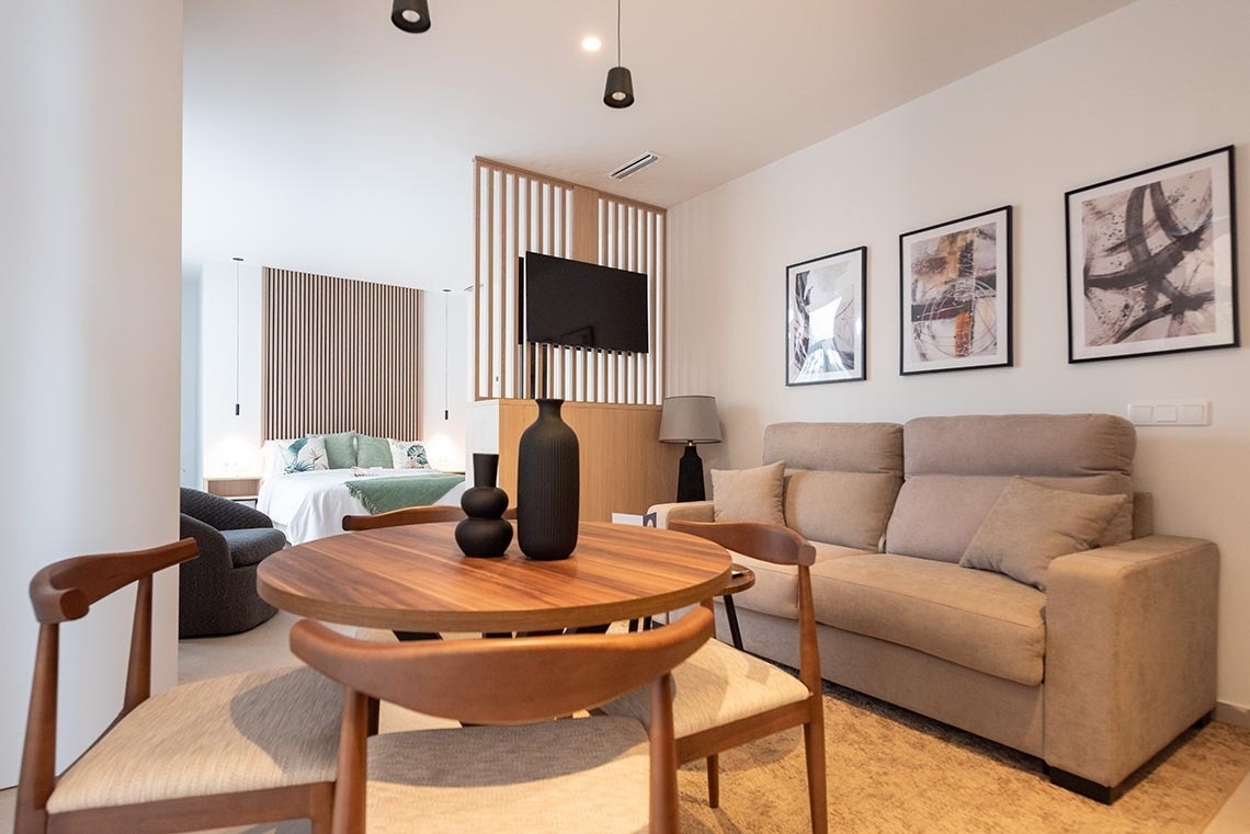 una sala de estar con una mesa de madera y sillas