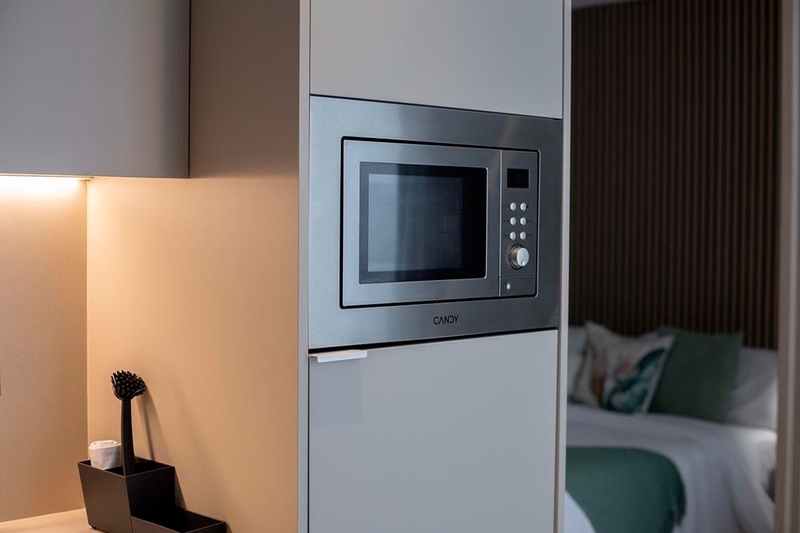 una cama con sábanas blancas y almohadas blancas