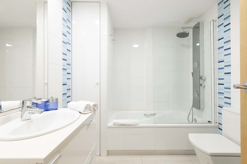 una cama con dos almohadas blancas y una cabecera de madera