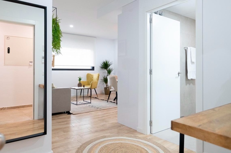 una cama con sábanas blancas y almohadas blancas