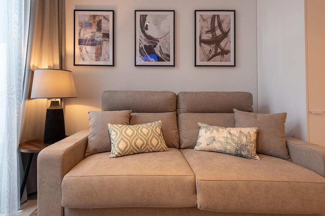 una sala de estar con un sofá y tres cuadros en la pared