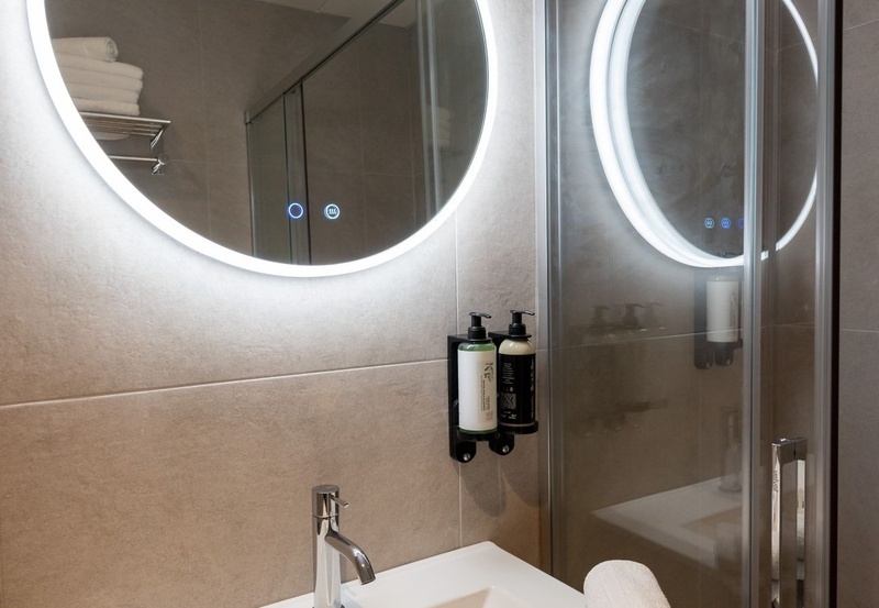 una cama con dos almohadas blancas y una cabecera de madera