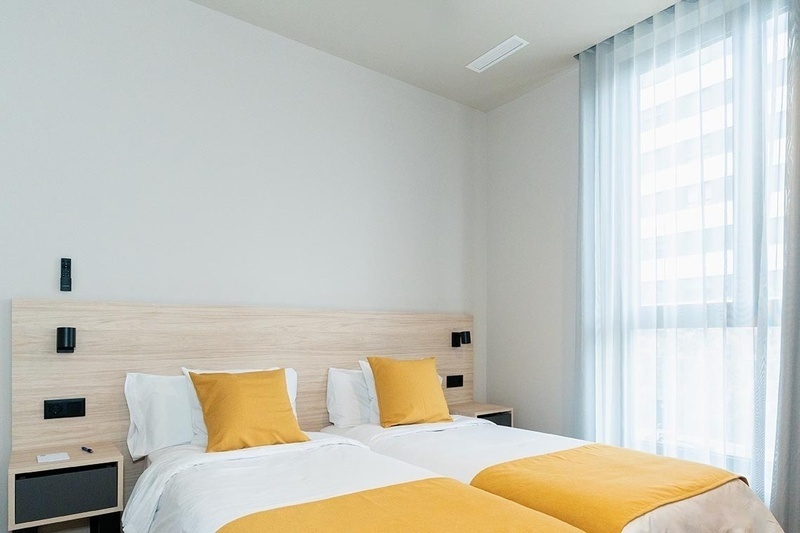 una cama con sábanas blancas y almohadas blancas