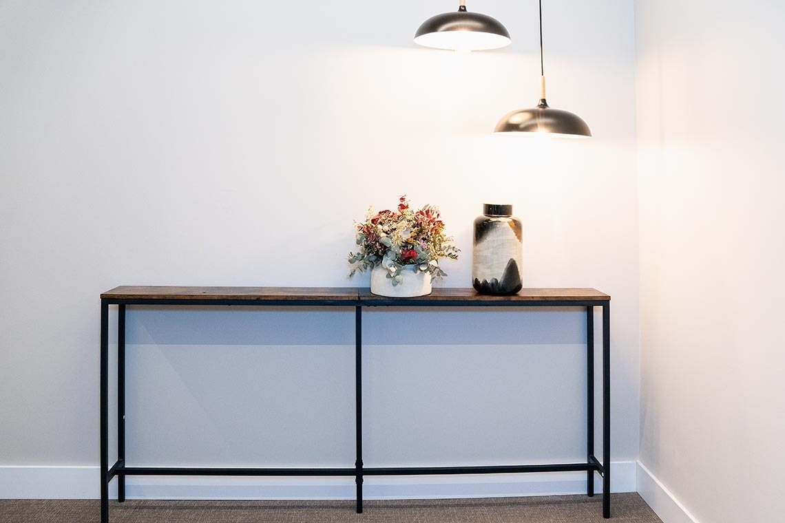 una mesa de madera con un jarrón de flores encima