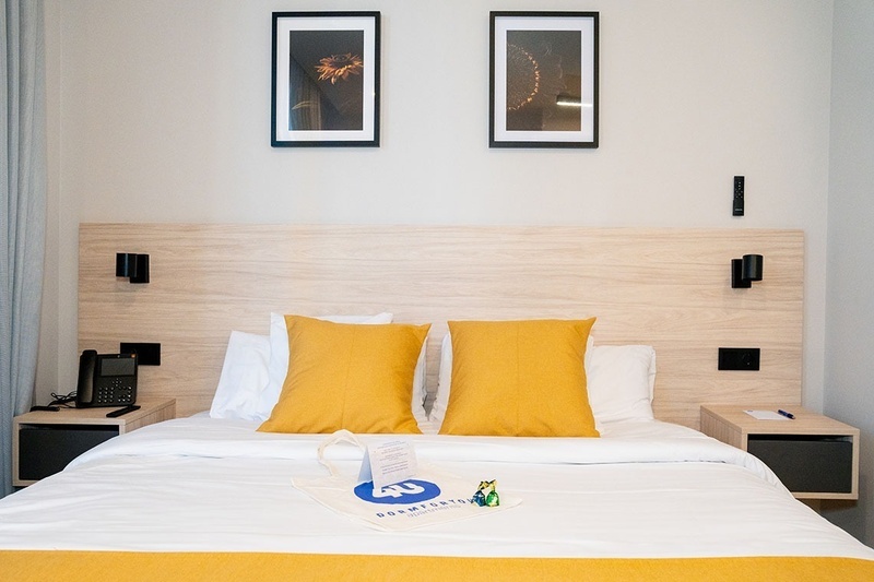 una cama con dos almohadas blancas y una cabecera de madera