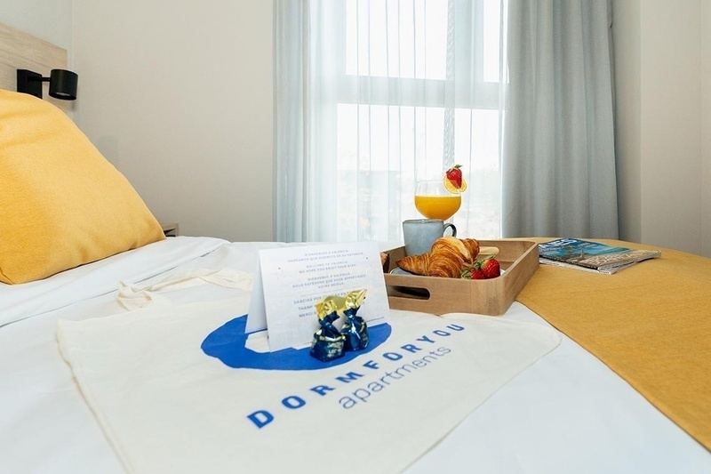 una cama con sábanas blancas y almohadas blancas