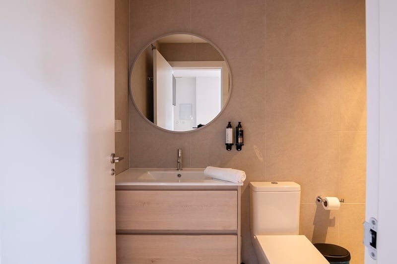 una cama con sábanas blancas y almohadas blancas